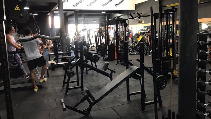 Área de musculação da unidade Jabotiana, com bancos, barras e alunos treinando