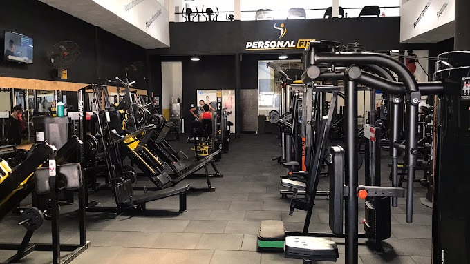 Salão de musculação da unidade Jabotiana, com fileiras de máquinas e a marca Personal Fit no painel do mezanino
